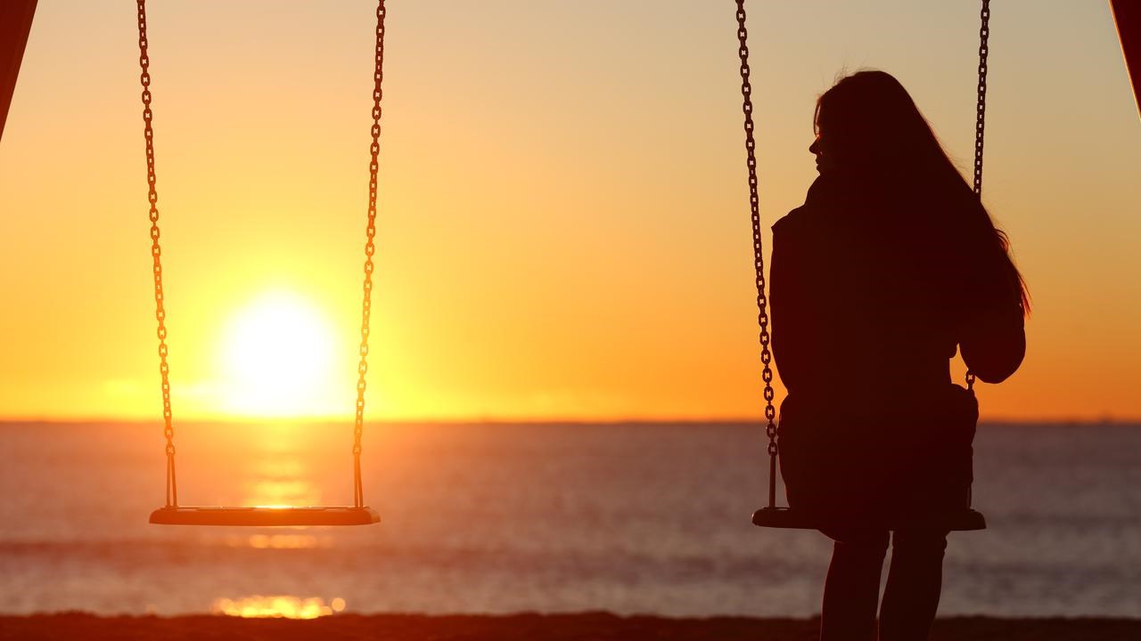 Kvinna på gunga i solnedgången. Bilden kan illustrera exempelvis ensamhet.