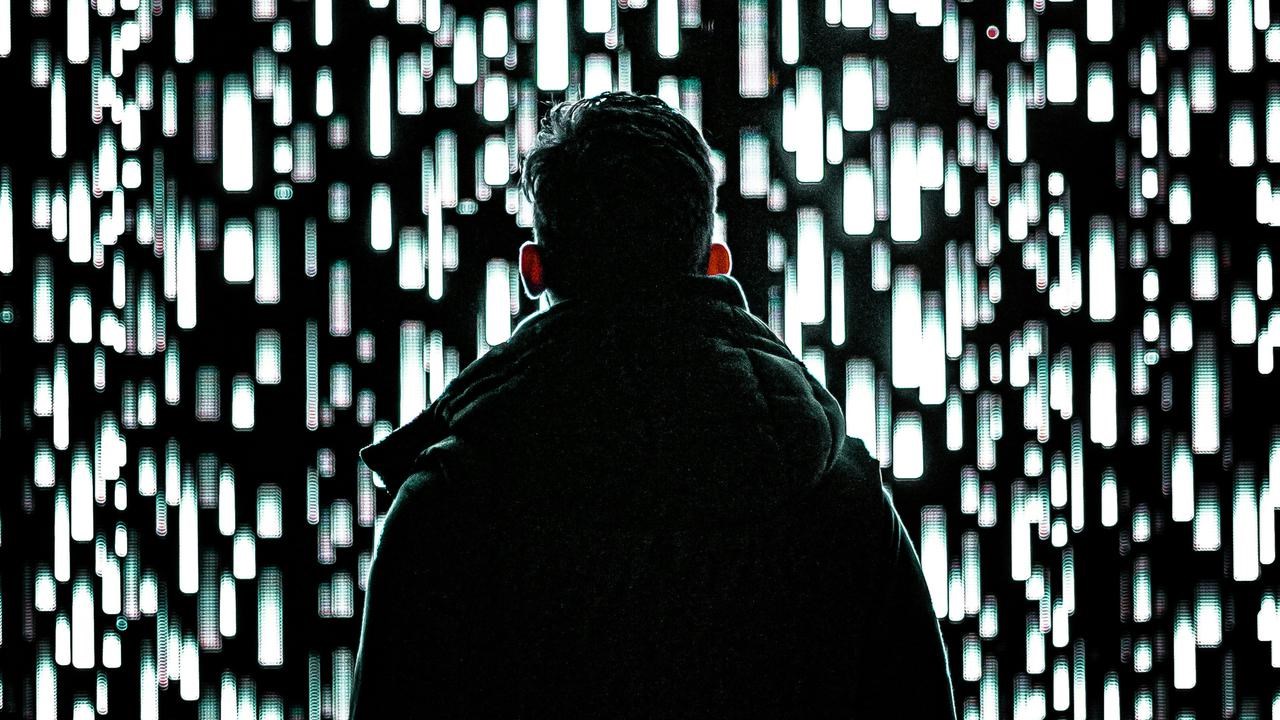 En man som står framför en vägg av ljus.