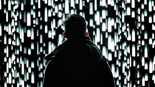 En man som står framför en vägg av ljus.