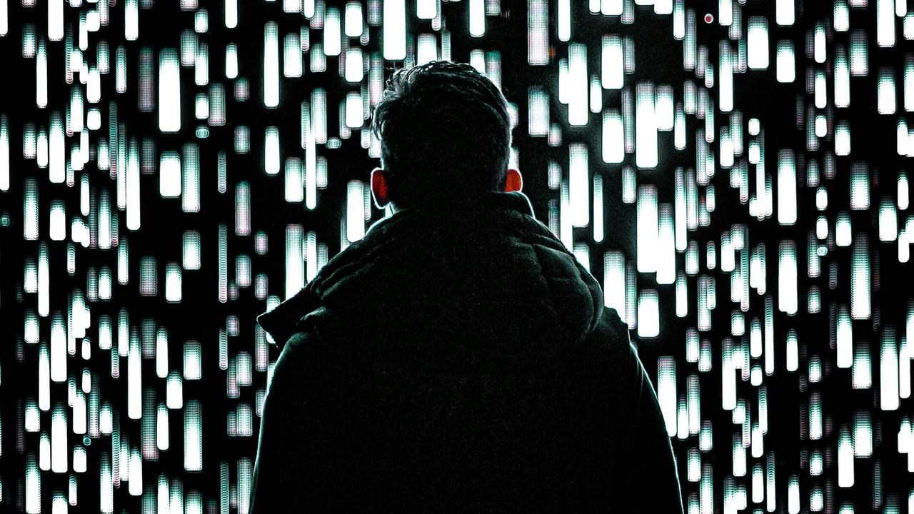 En man som står framför en vägg av ljus.