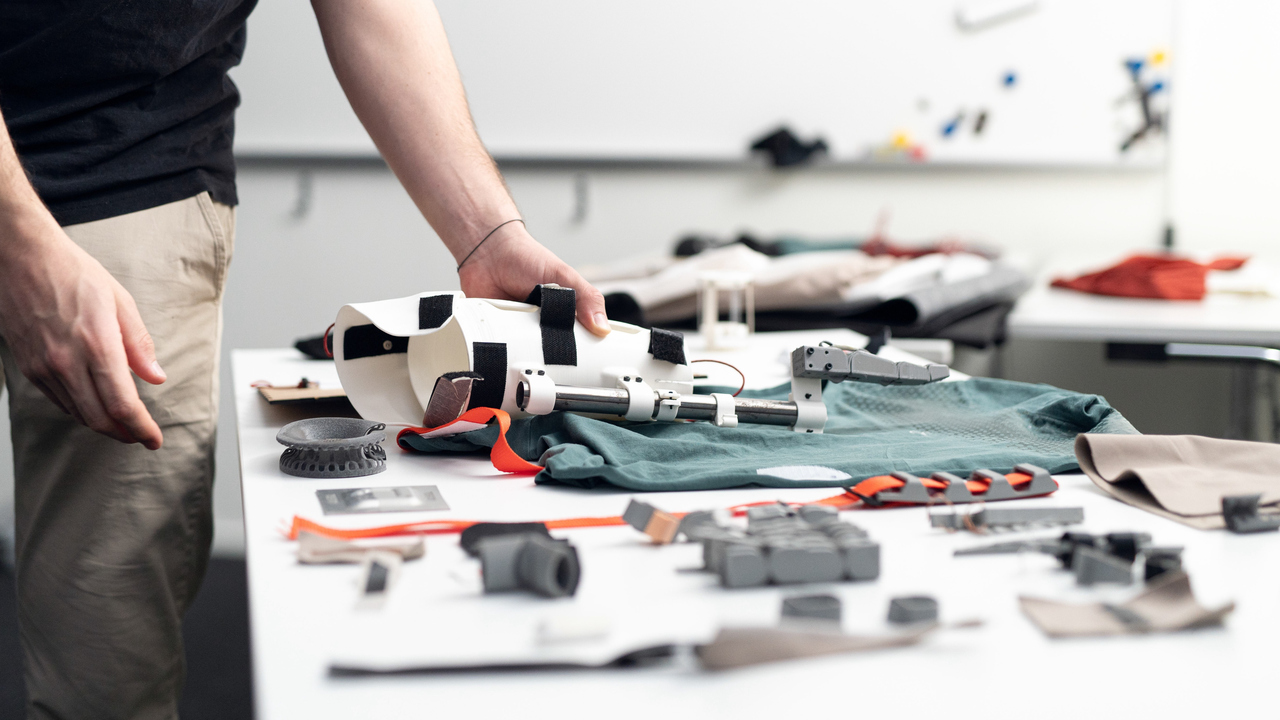 Närbild av en person som håller i en protes på ett bord.