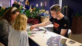 A group of people sitting around a table playing a game.