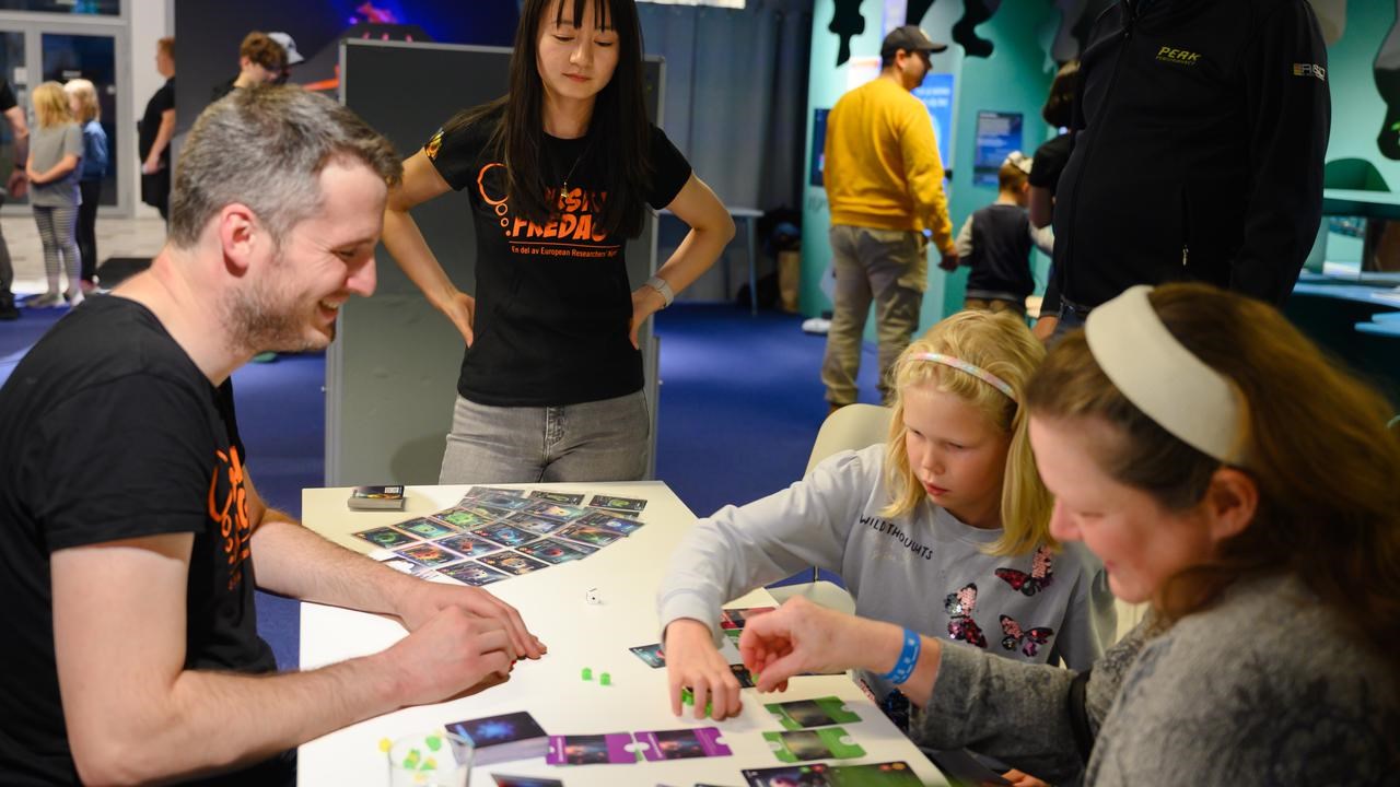 A group of people standing around a table.