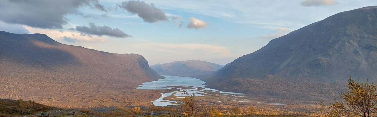 Vy över vattendrag genom fjällandskap.