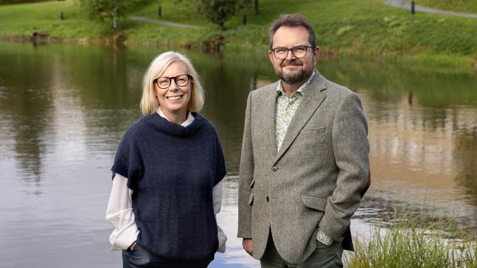 En man och en kvinna som står bredvid ett vattendrag.