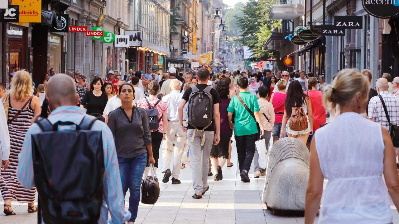 Sommardag på gågatan Drottninggatan mellan Mäster Samuelsgatan och Kungsgatan i Stockholm, Sverige, med folk i rörelse.