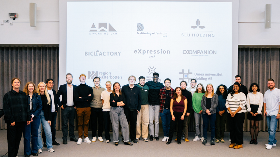 En grupp människor som står framför en projektorduk.