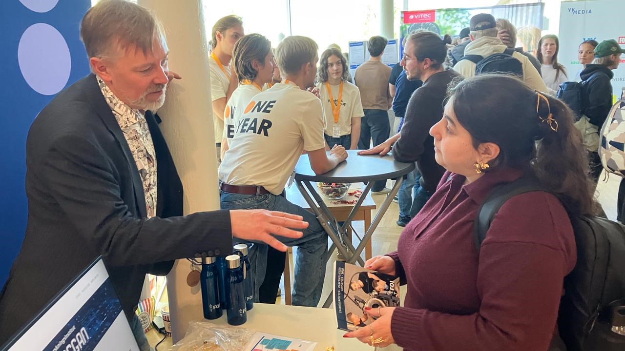 Bild på Anders Larsson på FOI och  Rand Al Kferi i samtal vid en monter.