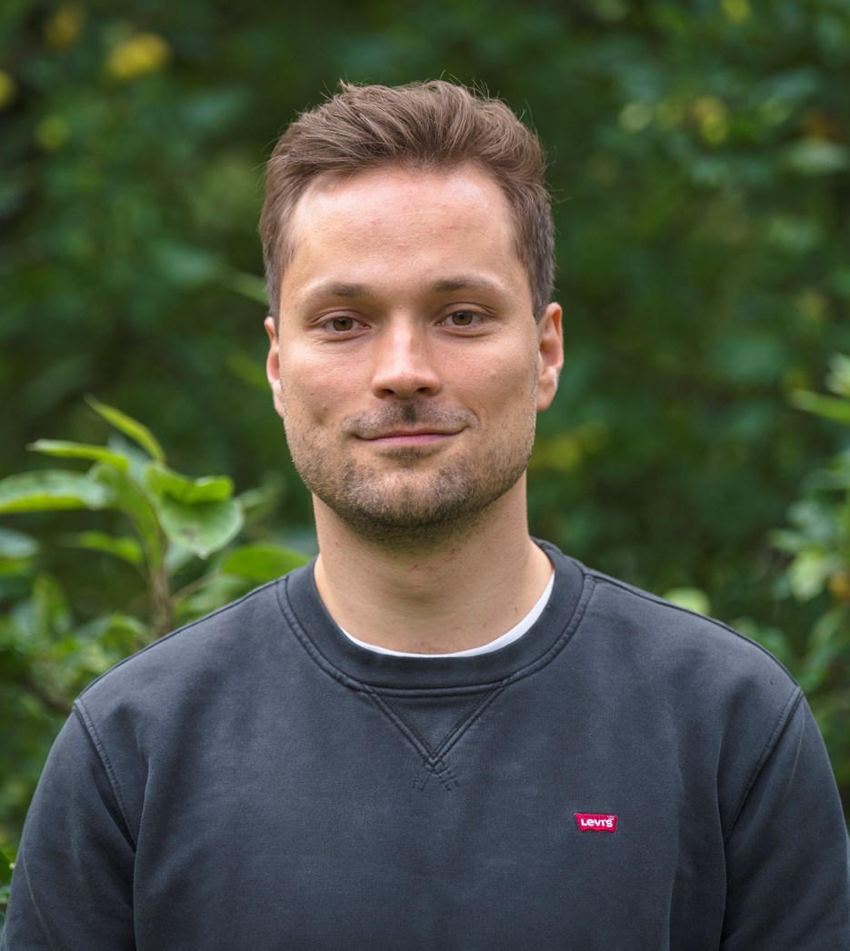 En man som står framför några träd