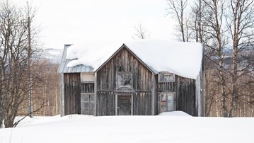 Övergivet tvåvåningshus i trä i fjällmiljö