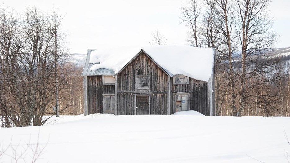 Övergivet tvåvåningshus i trä i fjällmiljö