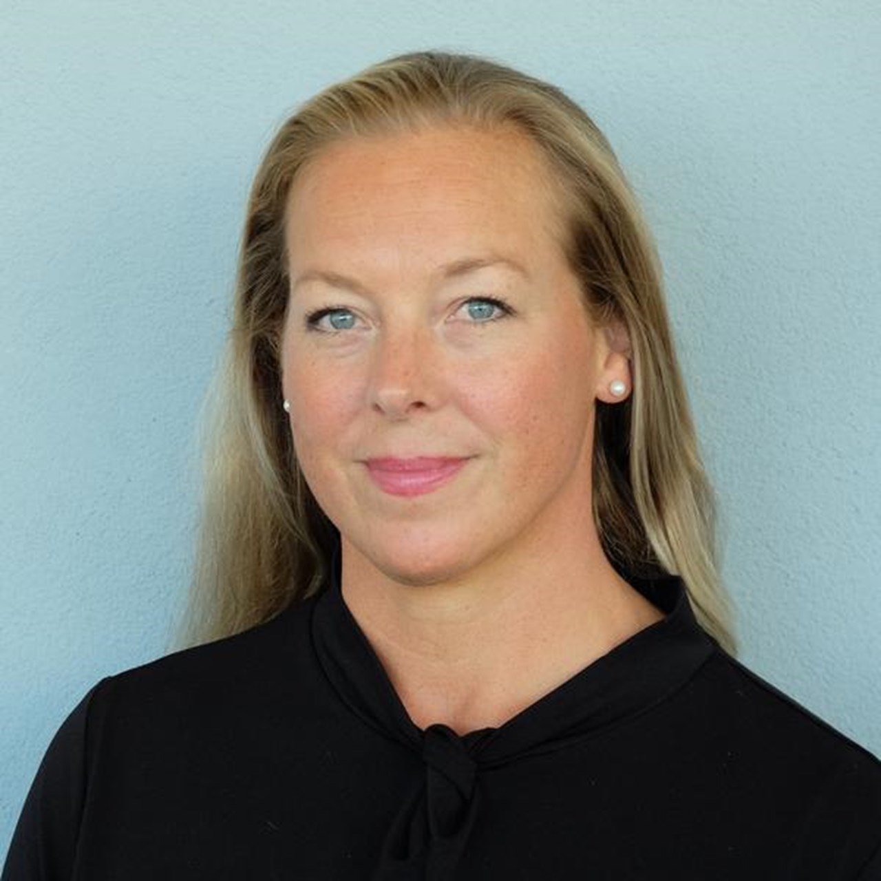 En kvinna i svart skjorta och blå vägg.