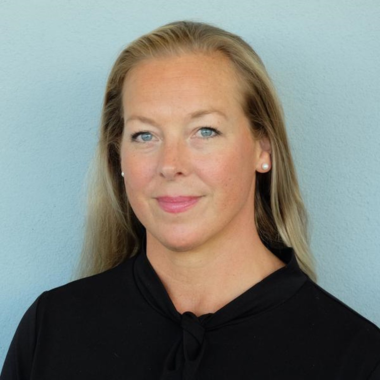 En kvinna i svart skjorta och blå vägg.