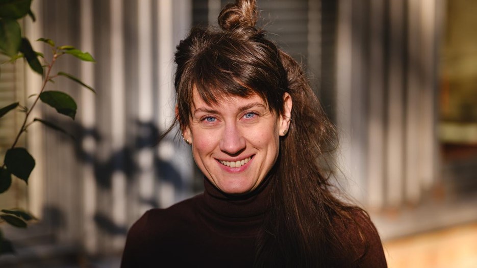 Porträtt på kvinna i lätt solljus utomhus.