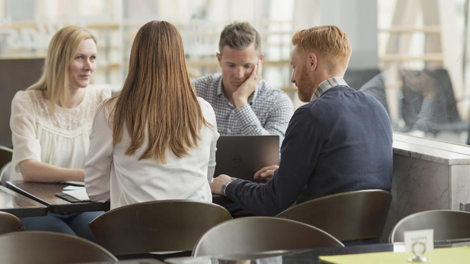 Människor sitter vid ett bord och samtalar.