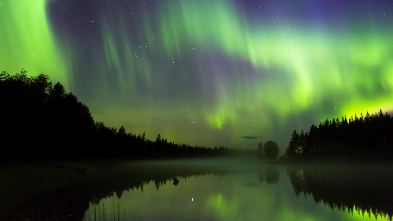 Norrsken som speglas i älven.