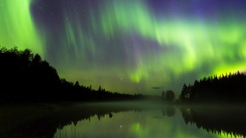 Norrsken som speglas i älven.