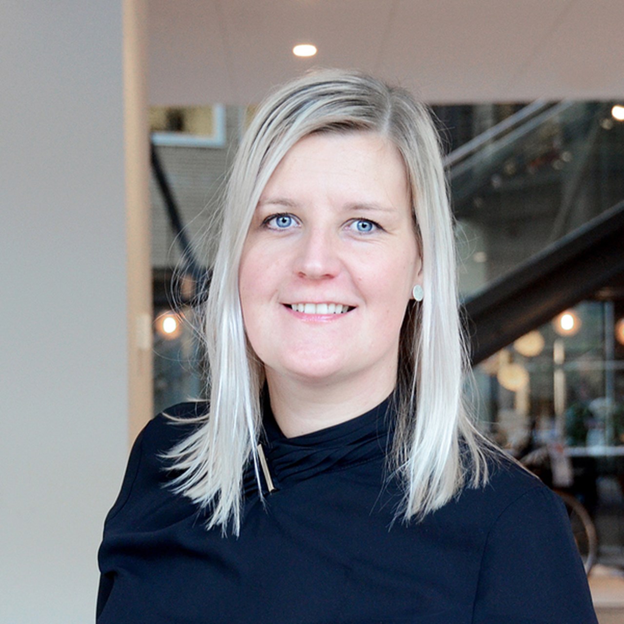 En kvinna i svart skjorta står i en lobby