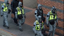 Personer iklädda skyddskläder och gasmasker under en beredskapsövning.