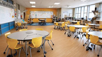 Ett klassrum med gula stolar och en whiteboardtavla.