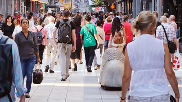 Sommardag på gågatan Drottninggatan mellan Mäster Samuelsgatan och Kungsgatan i Stockholm, Sverige, med folk i rörelse.