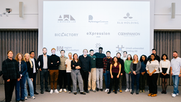 En grupp människor som står framför en projektorduk.