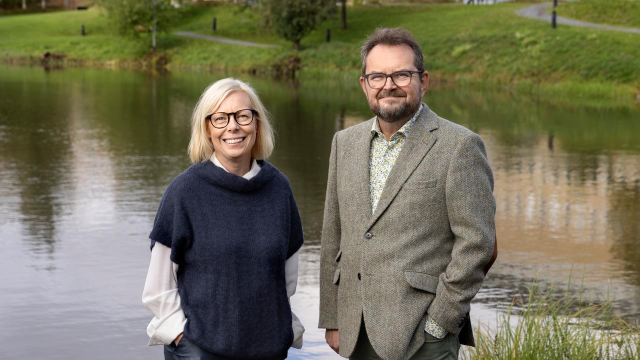 En man och en kvinna som står bredvid ett vattendrag.