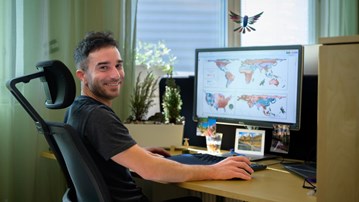 A man is sitting at a desk with a computer.