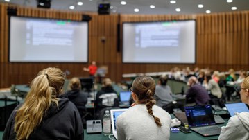 Några studenter sitter i en föreläsningssal och lyssnar på en föresläning.