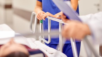 Detalj från en akutvårdsavdelning. Vårdpersonal med en patient på bår.