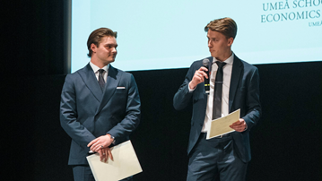 Två män står bredvid varandra på en scen.