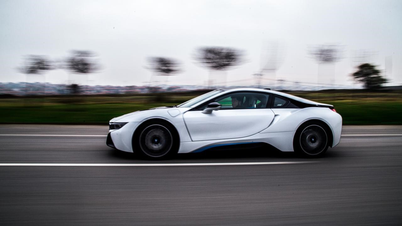 En vit sportbil som kör på vägen.