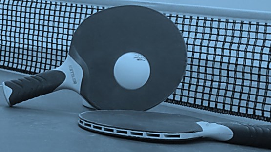 Two ping pong paddles and a racket on a tennis court.