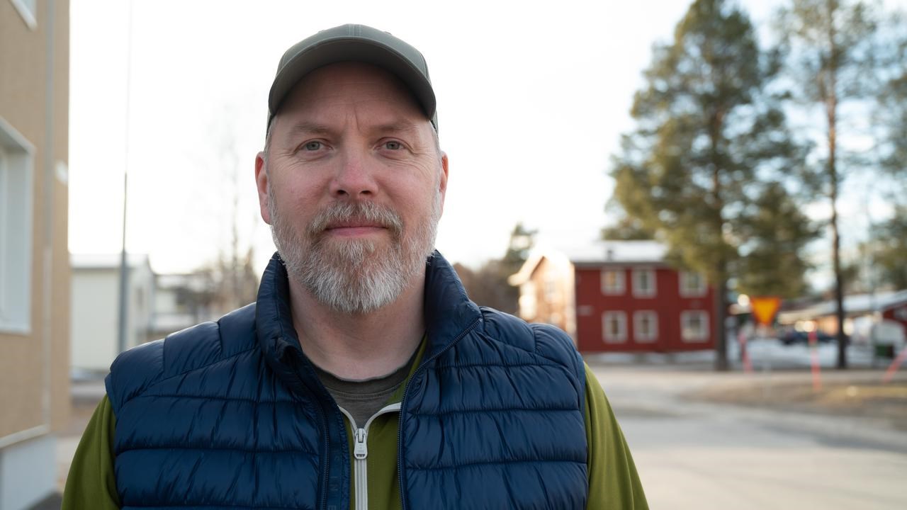 En man står framför en byggnad.