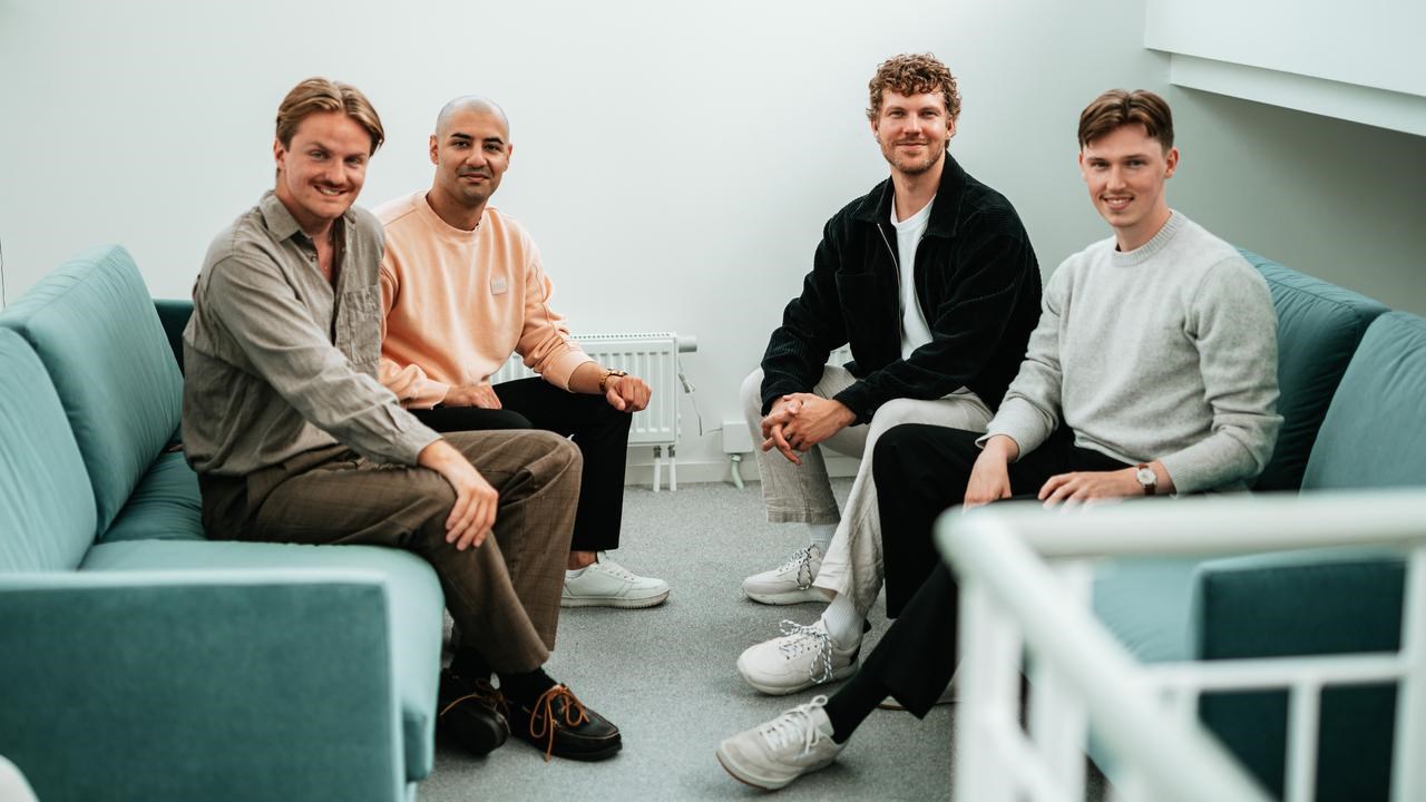 En grupp män sitter på en blå soffa.