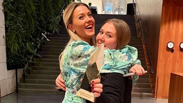 Michaela Östlund kramar Rebecka Ljunglöf, som håller i en pokal.