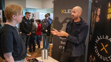 Bild på Jonas Reini i samtal vid Mårten Olofsson, Xlents, monter.