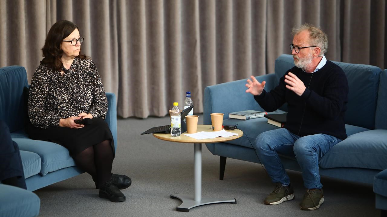 En man och en kvinna sitter i soffor och pratar.