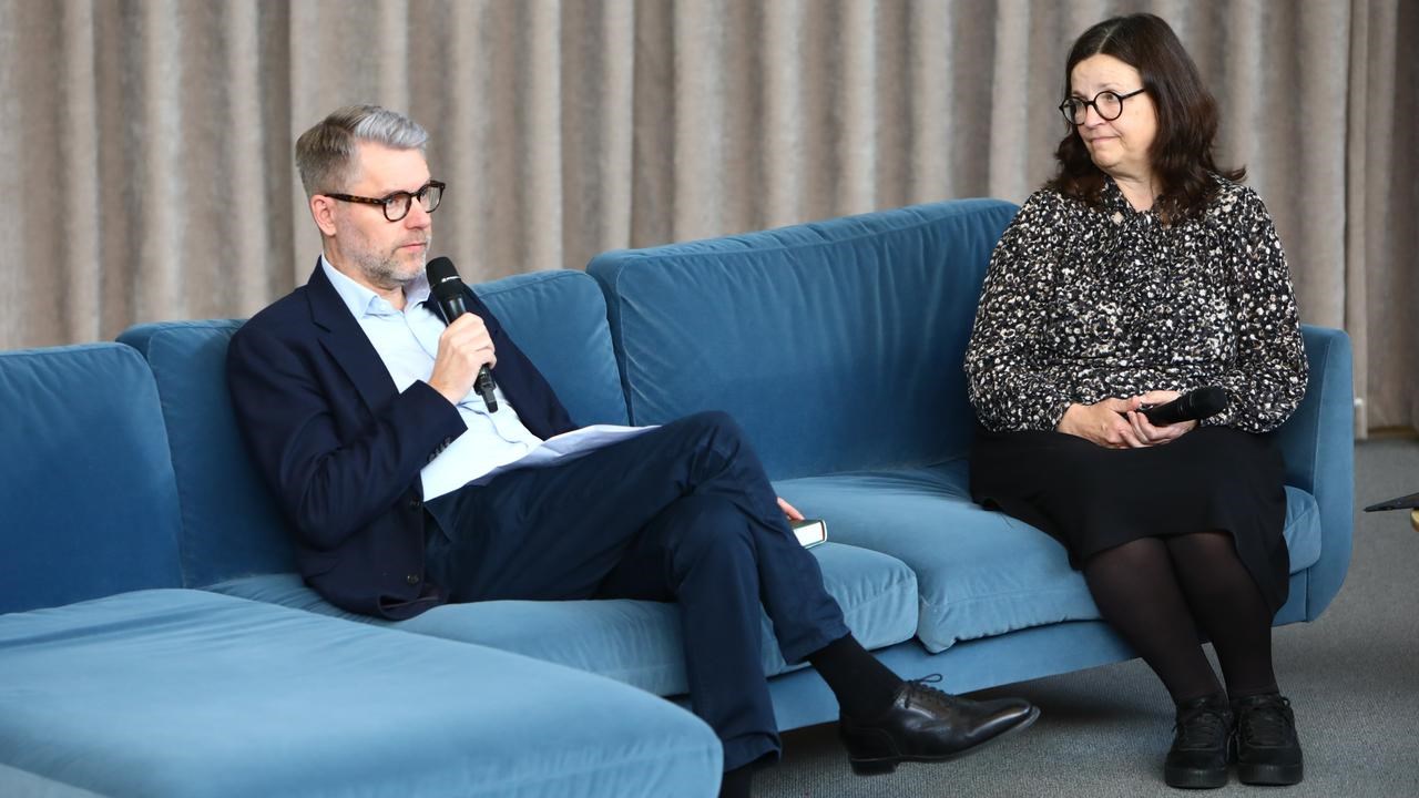 En man och en kvinna sitter i en blå soffa.