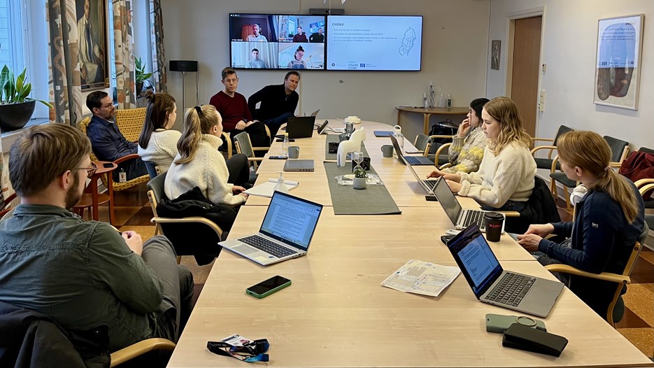 Doktoranderna vid den Arktiska forskarskolan sitter runt ett bord och grupparbetar