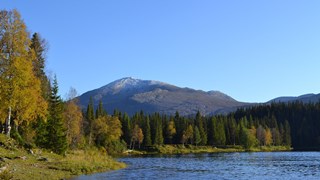 Bild på en sjö med blånande berg i bakgrunden