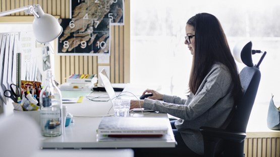 Kvinna sitter vid ett skrivbord och arbetar
