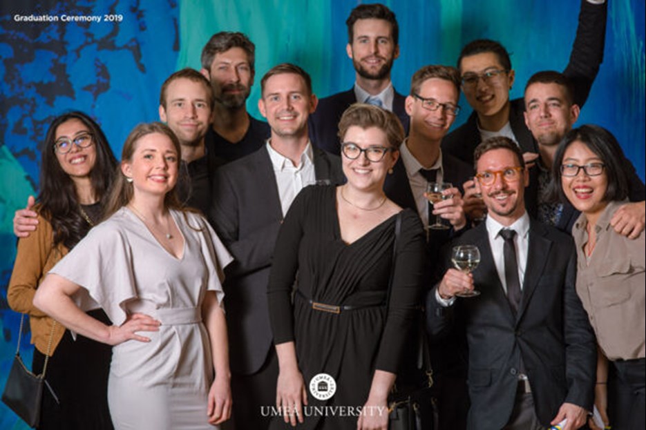 Gruppfoto med studenter framför backdrop med norrskensmotiv